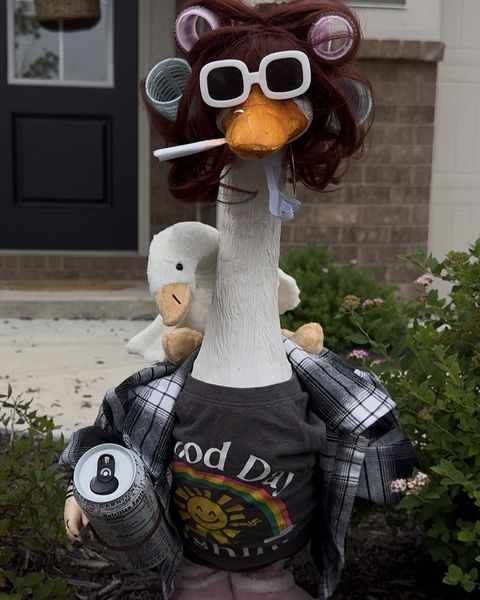 Lucy in hair curlers, white sunglasses, a flannel shirt and a Good Day Sunshine tee, holding a tumbler